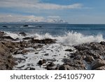 Russia. The Far East. The Kuril Islands. Waves of the Pacific Ocean beating against basalt rocks on the shore of Iturup Island.