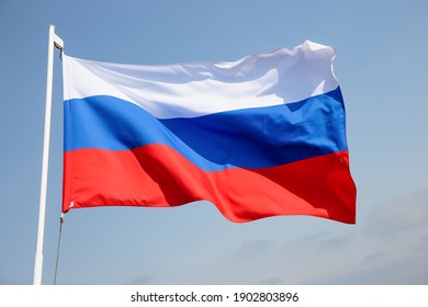 Russia flag is waving in front of blue sky. 