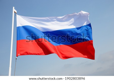 Russia flag is waving in front of blue sky. 