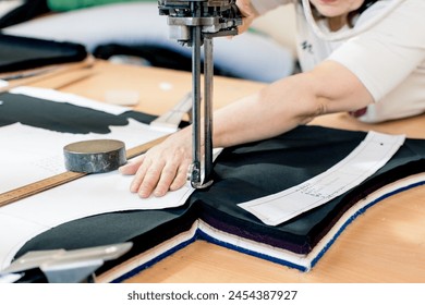 Russia, Kaluga - 04.09.2024. A woman makes clothing patterns with a tape knife. Work in the cutting shop.Tailoring for various brands. - Powered by Shutterstock