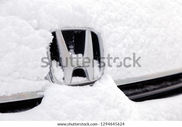 Russia\
Kemerovo 2018-12-23 closeup metal emblem brand icon Honda Stepwgn\
stands covered with fluffy snow. Concept Siberian northern weather,\
blizzard, snowfall and cold harsh\
conditions