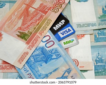 Russia, Kemerovo-25.10.2021. Plastic Cards Of Visa, Mir And Russian Banknotes Payment Systems