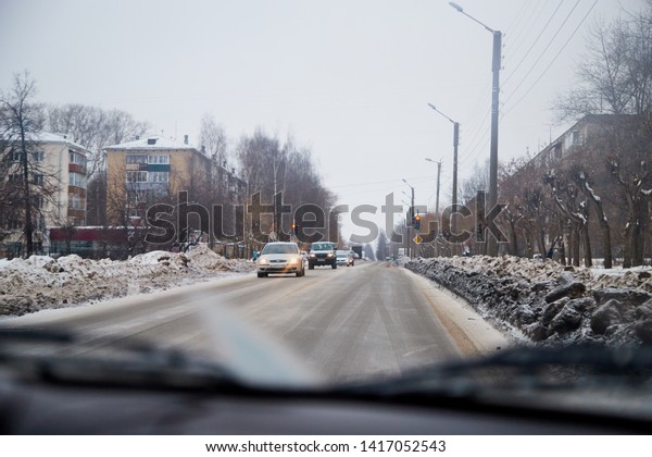 Russia, Kirov - January 01, 2018: City street with\
cars, traffic lights and dirty snow on the roadside in the winter\
day in the city in\
Russia