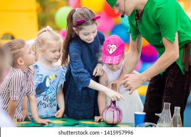 RUSSIA, KRASNODAR - MAY 31 2019: Animator, Dressed In Peter Pan Costume Conducting Chemical Experiments With Kids At The Birthday Celebration Party. Science And Magic Trick Show For Little Children.