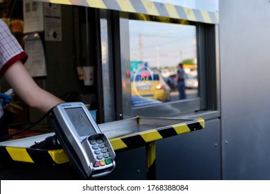 Russia Moscow 1.07.2020  McDonald’s Worker Holding Bag Of Fast Food. Hand Trough The Window Of Mcdonalds Car Mcauto. Window For Payment And Issuing An Order In Mcauto. 