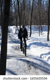 

Russia. Moscow - 22/02/20. A Cyclist Rides A Pump Track In Winter. A Rider In A Helmet Rides On A Snowy Pamptrack. Winter Bike Season