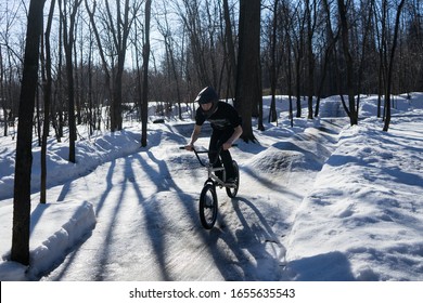 

Russia. Moscow - 22/02/20. A Cyclist Rides A Pump Track In Winter. A Rider In A Helmet Rides On A Snowy Pamptrack. Winter Bike Season