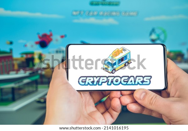 Russia Moscow 25.12.2021 Logo of metaverse\
CryptoCars. Blockchain nft ethereum cryptocurrency strategy\
game.Man playing in mobile phone. Crypto coin,token. Earning\
digital money.\
Play-to-earn.
