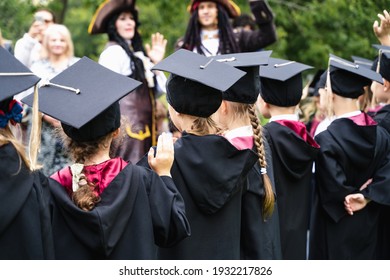 Russia Moscow 30.08.20.Back to primary school. Small children go to first grade.Graduating ceremony.Black gowns,academic caps,tassels.Party with parents, teachers in park, yard. Last day, end of year.