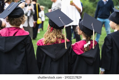 Russia Moscow 30.08.20.Back to primary school. Small children go to first grade.Graduating ceremony.Black gowns,academic caps,tassels.Party with parents, teachers in park, yard. Last day, end of year.