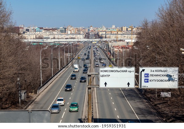Russia, Moscow, April 10, 2021.\
Panorama of Moscow, Luzhniki Bridge, cars driving on the road, blue\
sky. Text on the billboard: street names, center, 3rd\
ring.