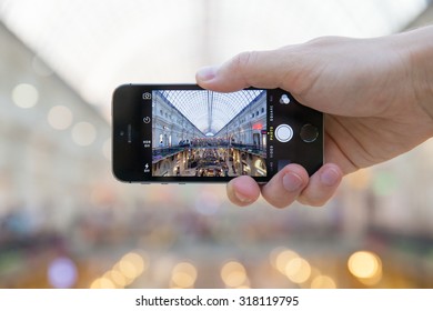 Russia, Moscow - July 25, 2015: The Hand Of Young Man Who Is Taking The Picture Inside Historical GUM Department Store With His Smartphone On July 25, 2015 In Moscow, Russia.