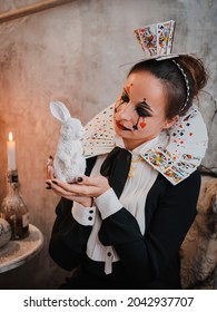 Russia Moscow October 30, 2019 Young Woman With Spooky Makeup Wearing Queen Of Hearts Costume With Card Collar With A Rabbitvisiting Night Halloween Party.