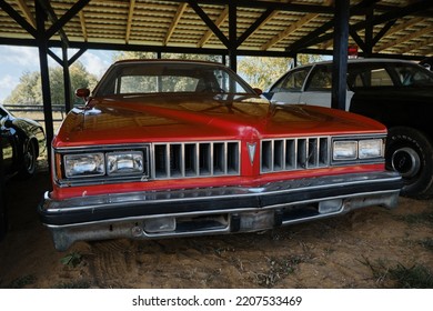 Russia, Moscow - September 2022. Old Retro Vintage Pontiac Red Sports Car Of The 20th Century With Chrome Bumpers Stands Outside Under Canopy At Car Show. Front View.