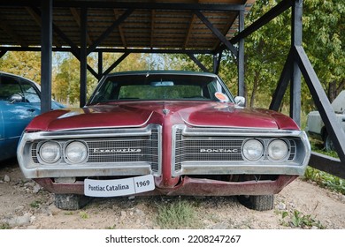 Russia, Moscow - September 2022. Old Retro Vintage Red Sports Car Pontiac Catalina Of 20th Century With Chrome Bumpers Stands Outside Under Canopy At Car Show. Front View.