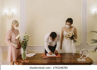 RUSSIA, NOVOMOSKOVSK - JULY 07, 2020: Masked Bride And Groom During A Wedding Ceremony. Weddings During The Period Of Quarantine And Pandemic Of Coronavirus Infection