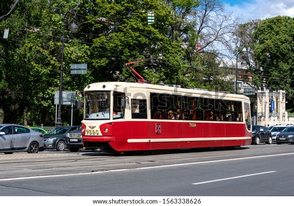 Russia, Saint Petersburg, near Peter and Paul\
Fortress: Street scene with public transport tramway tram at\
Troitskaya Square in the city center of the Russian town with green\
trees. Jul 08, 2019
