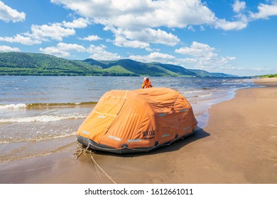 Russia Samara July 2019: Inflatable liferaft on the Volga River against the backdrop of the Zhiguli Mountains on a summer sunny day.