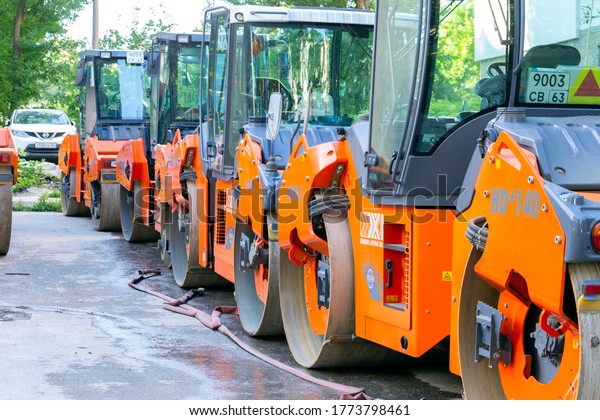 Russia Samara June 2020 :.\
Special equipment. Modern road rollers for compaction of the\
pavement are in a break on the sidewalk. Text in Russian:\
twenty-first century