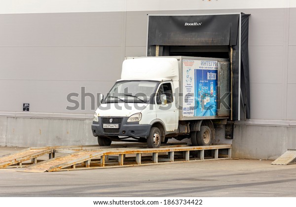 Russia Samara March 2020: A large van stands\
unloading outside a warehouse on a summer day. Russian text:\
integrita, high quality food products for restaurants and bars,\
moscow, saint\
petersburg.