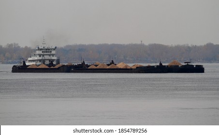 Russia, Samara - October 08/2020:A River Pusher Tug Drives A Train Of Two Barges Loaded With Sand And Rubble Along The River.