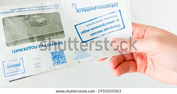 Russia, Samara, October 2020: a hand holds\
a letter with notification of traffic violations. Text in Russian:\
Samara, non-refundable, I receive it in electronic form, save your\
time, registration.