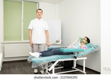 Russia, Samara
September 09, 2021 .
Young male doctor with long hair puts on an oxygen mask to a brunette girl lying on a blue medical couch in a treatment room in a private medical clinic