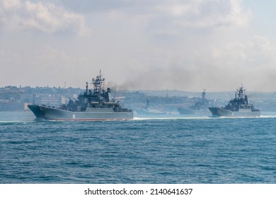 Russia, Sevastopol - July 21, 2021:  Group Of Modern Russian Warships Sails In Sevastopol Bay During Russian Navy Day Rehearsal In A Sunny Day Next To Anchored Battle Ships. 