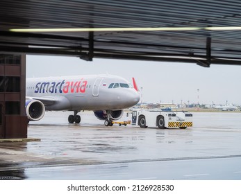 Russia, Sochi 02.11.2021. An Airplane With An Airfield Tug Stands On The Runway On A Cloudy Day