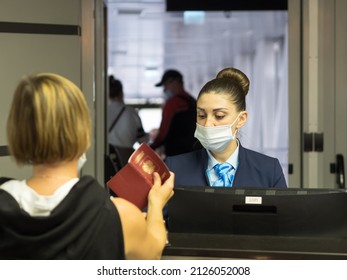 Russia, Sochi 02.11.2021. An Airport Worker Checks Passengers' Documents And Lets Them Board The Plane. Focus On The Girl In The Mask