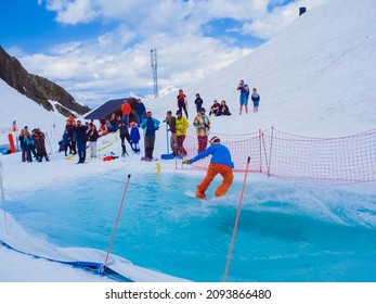 Russia, Sochi 11.05.2019. A guy on a snowboard crosses a pool of water without falling. Snowboard competition on the water in the Krasnaya Polyana ski resort.