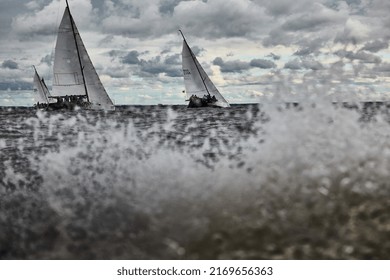 Russia, St. Petersburg, 17 June 2022: Splashes Of Water In Sailing Regatta, Teamwork In Sailing Yacht At Stormy Weather, Hot Pursuit, Clouds Sky 