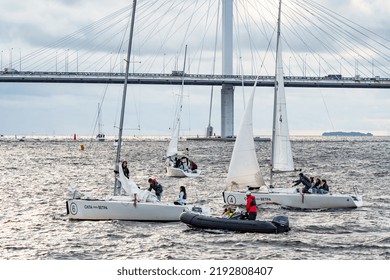 Russia, St. Petersburg, 29 July 2022: Few Small Sport Sailing Boats At Sunset With Stormy Sky, Sailing Regatta, Teamwork, Hot Pursuit, Highly Cable-stayed Bridge On Background