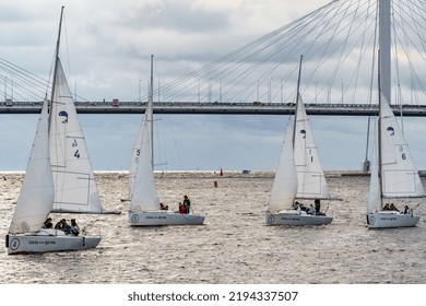 Russia, St. Petersburg, 29 July 2022: Few Small Sport Sailing Boats At Sunset With Stormy Sky, Sailing Regatta, Teamwork, Hot Pursuit, Highly Cable-stayed Bridge On Background