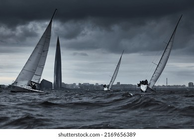 Russia, St.Petersburg, 17 June 2022: Teamwork In Sailing Regatta At Stormy Weather, Skyscraper Lakhta Center Of Gas Company Gazprom On Background, The Cloud Sky, Hot Racing