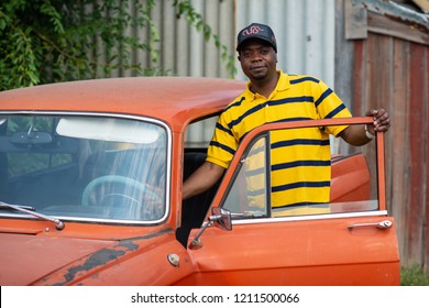 RUSSIA, SYZRAN - SEPTEMBER 2, 2018: African American Man Sitting In The Front Seat Of An Old Car With The Door Open