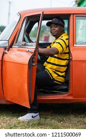 RUSSIA, SYZRAN - SEPTEMBER 2, 2018: African American Man Sitting In The Front Seat Of Old Car With The Door Open