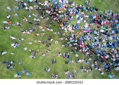 Russia, Tatarstan, July 10, 2019: A Large Crowd Of People Arbitrarily Settled On A Green Lawn And Listens To A Musical Concert. Shooting From A Drone.