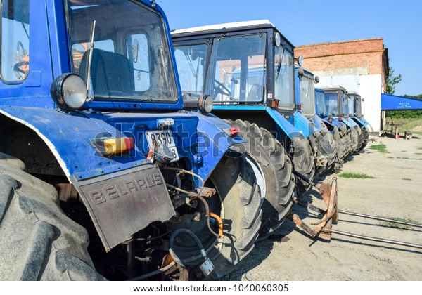 Russia, Temryuk - 15 July 2015: Tractor. Agricultural\
machinery tractor. Parking of tractor agricultural machinery. The\
picture was taken at a parking lot of tractors in a rural garage on\
the