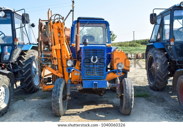 Russia, Temryuk - 15 July 2015: Tractor. Agricultural\
machinery tractor. Parking of tractor agricultural machinery. The\
picture was taken at a parking lot of tractors in a rural garage on\
the