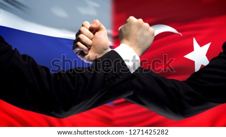 Russia vs Turkey confrontation, countries disagreement, fists on flag background