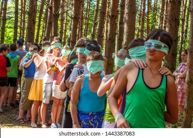 RUSSIA, YAROSLAVL - 30 JUN 2012: Group Happy Children And Adult Teens Relax In Summer Forest Tent Camp Play Active Games On Banks Volga River Participate In Competitions On Bright Sunny Day