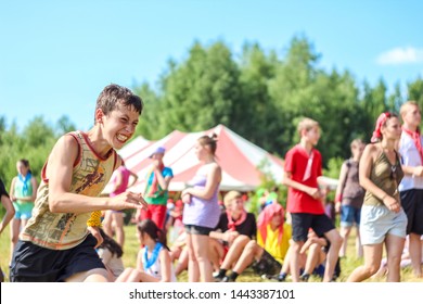 RUSSIA, YAROSLAVL - 30 JUN 2012: Group Happy Children And Adult Teens Relax In Summer Forest Tent Camp Play Active Games On Banks Volga River Participate In Run Competitions On Bright Sunny Day