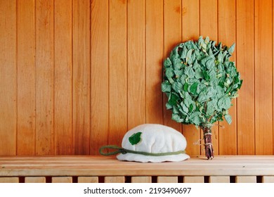 Russian Bathhouse Background. Accessories for Sauna: Hat and Birch Broom. Stock Photo