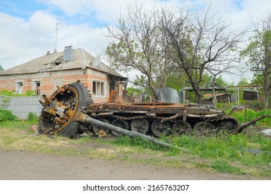 Russian Battle Tank Remains With Torn Down Gun Turret Which Was Destroyed During Russian Invasion Of Ukraine. Russian Tank Was Hiding In The Yard Of Ukrainian Village.