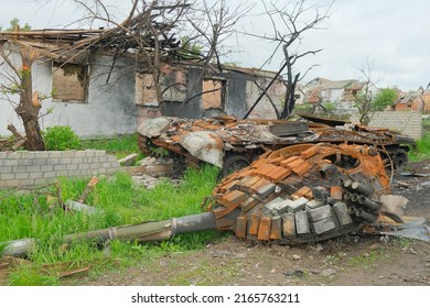 Russian Battle Tank Remains With Torn Down Gun Turret Which Was Destroyed During Russian Invasion Of Ukraine. Russian Tank Was Hiding In The Yard Of Ukrainian Village.