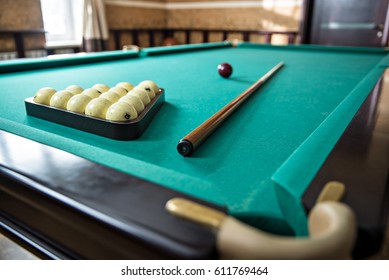 Russian billiard table with balls and cue sticks on a green background.