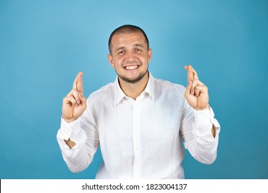 Russian Business Man Wearing White Shirt Standing Over Blue Background Gesturing Finger Crossed Smiling With Hope