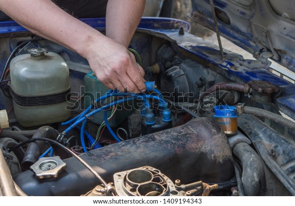 Russian car\
repair. Auto mechanic working in garage. Repair service. Repairing\
engine. Car engine bay open\
hood.