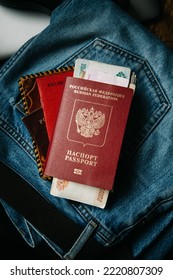 Russian Documents And Cash Money Are Lying On A Stick Of Things, The Man Is Going To Leave Russia So As Not To Participate In The War. Translate: Russian Federation Passport, Military Ticket.